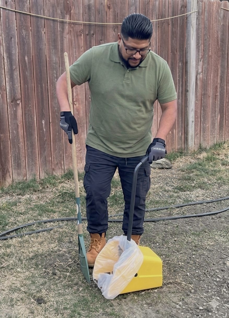 Josue, owner of Scoop Dogg, cleaning a backyard